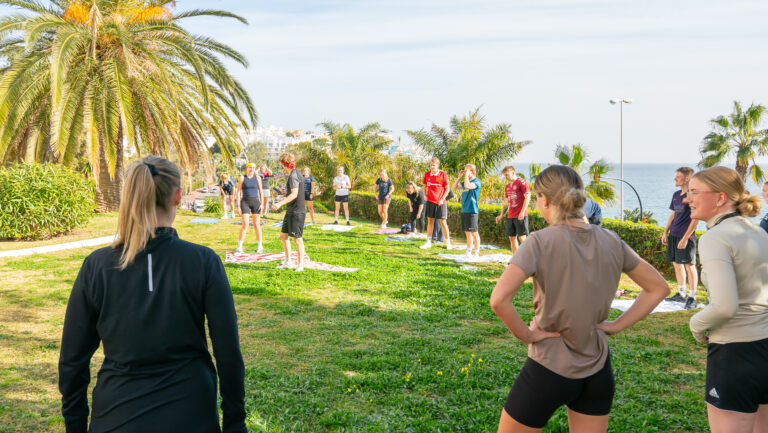 Elever på Costa del Sol guideskolen laver fitness med højt humør og masser af energi i en gruppe.